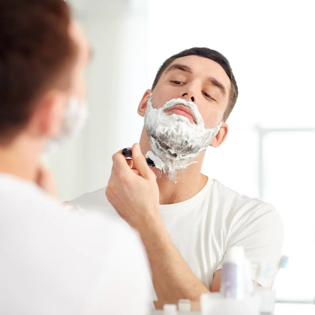 Man's jawline showing post-shave redness in soft bathroom light